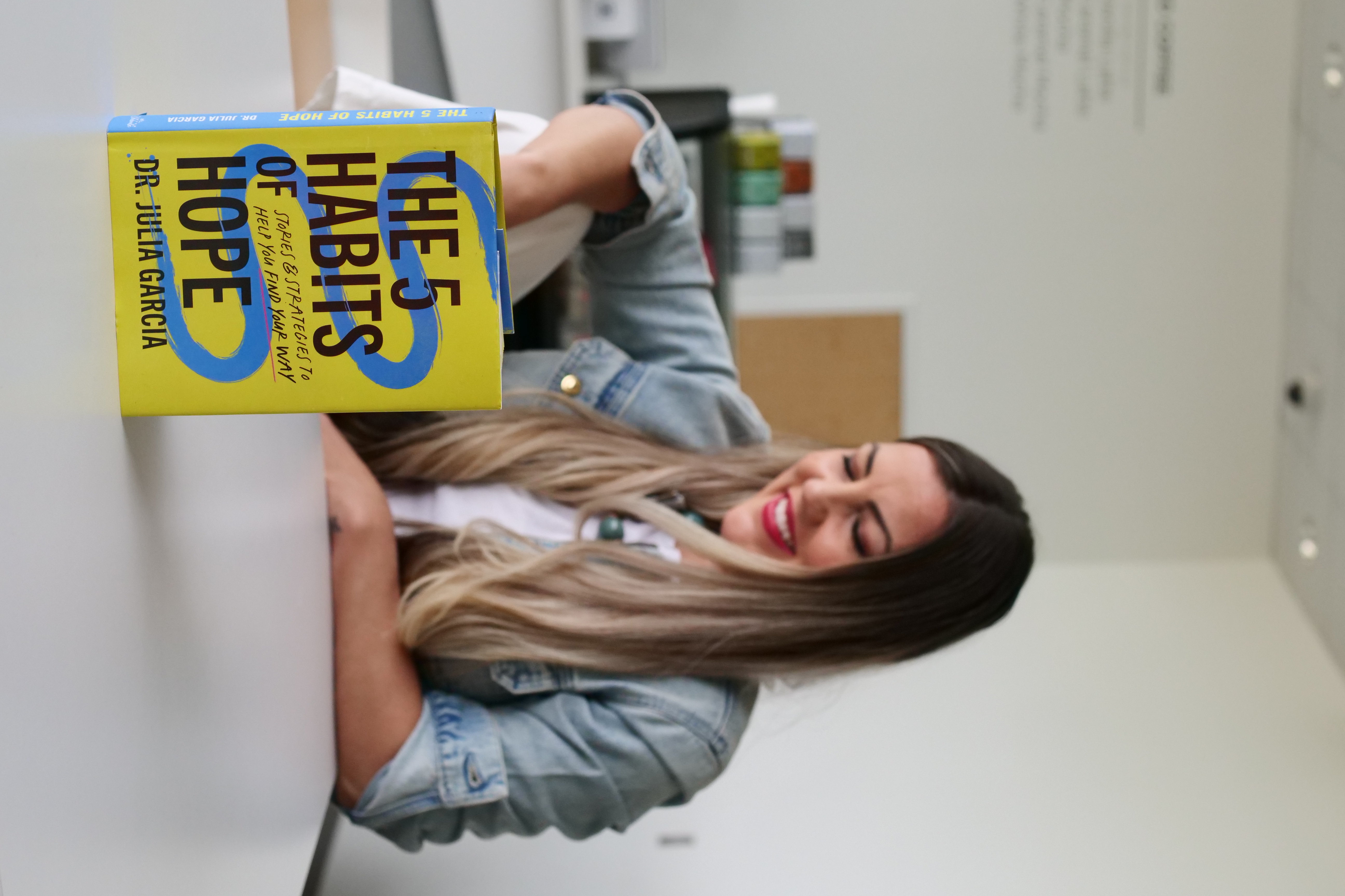 Dr. Julia Garcia holding The 5 Habits of Hope